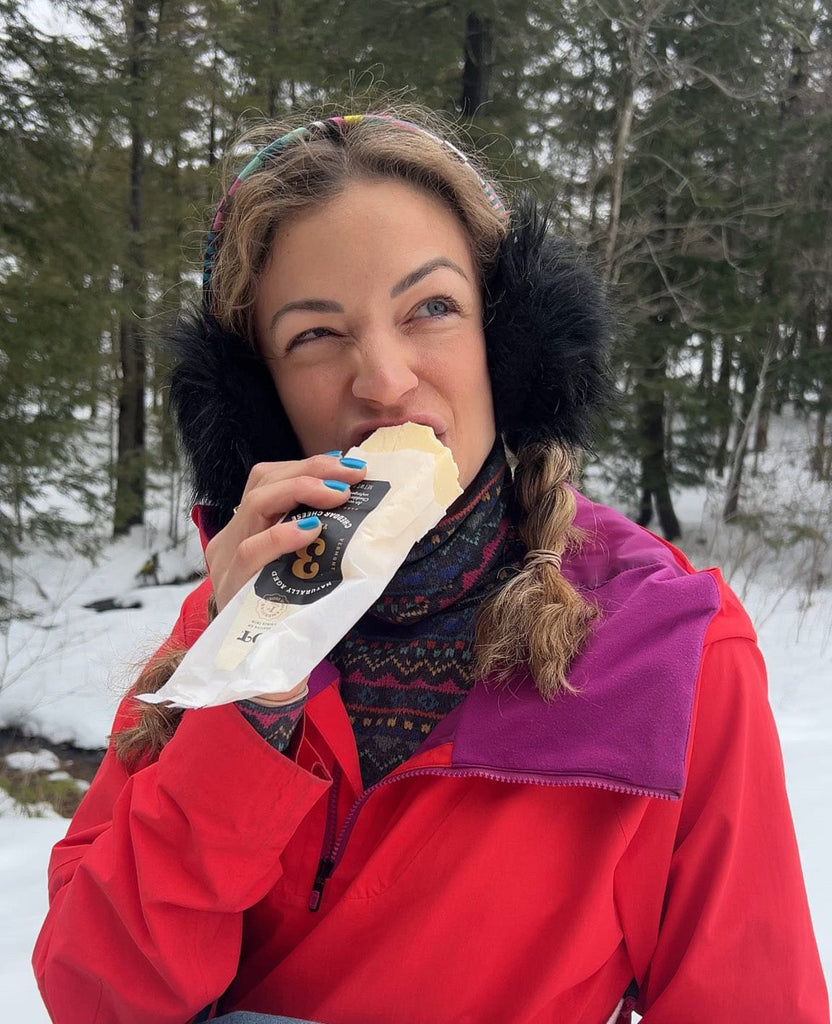 Woman eating a block of Cabot Cheese