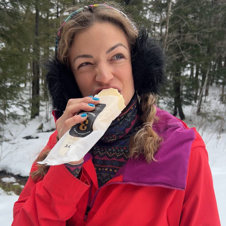 Woman eating a block of Cabot Cheese