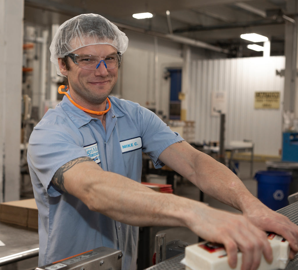 A young man packing cheese at a Cabot plant.