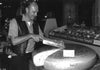 man cutting a giant wheel of cheese