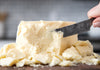 Block of Cheese being cut