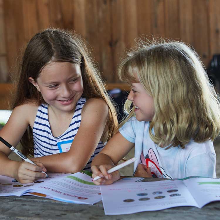 Two girls talking and drawing