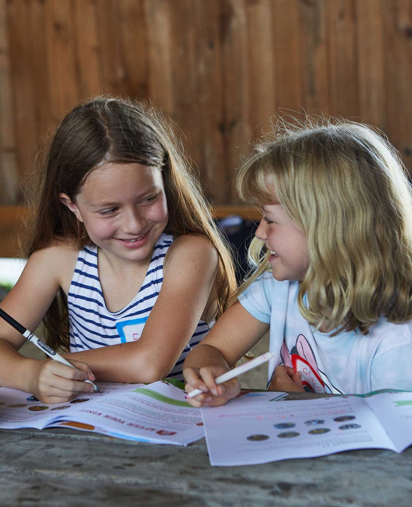 Two girls talking and drawing