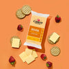 A package of Cabot Creamery Gouda Cheese, served with cheese slices, round crackers, and whole strawberries on an orange background.