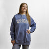 A woman wearing a blue New Duds Cheddar Crewneck with CHEDDAR printed in large white letters across the chest.
