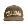 The New Duds Cheddar Corduroy Hat in Walnut features the word “CHEDDAR” embroidered in large, cream-colored letters on the front.