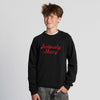 Smiling teenage boy with tousled brown hair wearing the New Duds Seriously Sharp Chainstitch Crewneck in black and grey jeans, standing against a plain light background.