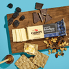 A bar of Cabot Creamery Extra Sharp Cheddar Cheese with crackers served on a wooden board.