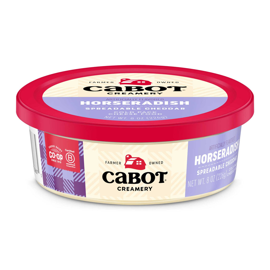 Cabot Creamerys Horseradish Cheddar Cheese, in an 8 oz round container with a red lid, features a purple and cream label showcasing its farm logo and farmer-owned roots. As a certified B Corporation product, its perfect for those seeking bold horseradish-flavored cheese.