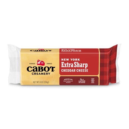 An 8 oz (226g) block of Cabot Creamery New York Extra Sharp Yellow Cheddar Cheese in red and yellow packaging, labeled "Farmer Owned" and "Premium Naturally Aged sharp Cheddar.