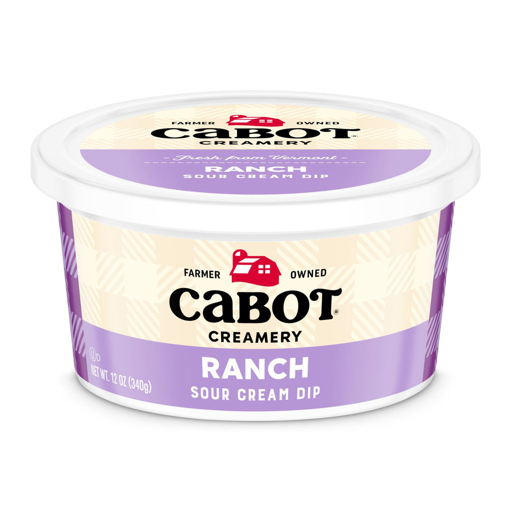 A 12 oz Cabot Creamery Ranch Dip comes in a container with a white lid and a light purple and cream label featuring the Cabot logo, product name, and Farmer Owned above the logo for this tangy ranch dip.