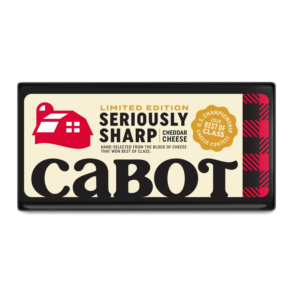 A rectangular package of Cabot Creamery Limited Edition Seriously Sharp Cheddar Cheese, featuring a red barn logo, gold award seal, bold black text on cream background, and labels reading “Limited Edition” and “Best of Class.”.