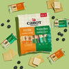 A package of Cabot Creamery Gouda & Sharp Variety Pack Cheese Snacks, with individual Gouda and Vermont Sharp Cheddar bars, is paired with crackers and blueberries on a light green background.