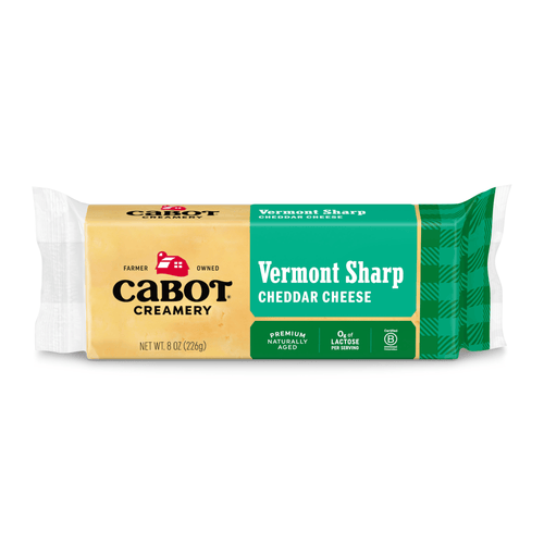 An 8 oz package of Cabot Creamery Vermont Sharp Yellow Cheddar Cheese, with yellow and green labeling, features the Cabot logo. This premium kitchen staple is naturally aged, sharp Cheddar, and lactose-free.