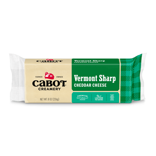 Cabot Creamery Vermont Sharp Cheddar Cheese, premium and naturally aged, comes in green and tan packaging, is lactose-free, and weighs 8 oz (226 g).