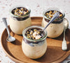 Three jars of Chocolate Topped Peanut Butter Yogurt cup dessert on a wooden plate with spoons.