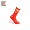 The Cabot x Darn Tough Socks, Orange by Darn Tough Vermont, inspired by vibrant farm landscapes, stand upright with a geometric design. A label in the corner reads 10% of Sales Donated, set against a crisp white background.