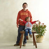 man wearing cheddar hoodie and young boy sitting on a stool wearing a Big Cheese 3/4 Sleeve shirt with a plant next to them.