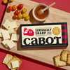 Cabot's Limited Edition Seriously Sharp Cheddar Cheese U.S Championship 2025 Best of Class Cheese Contest Winner on cutting board with tomatoes, crackers and honey and cheese sliced up.