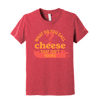 The Nacho Cheese Youth T-Shirt by New Duds features yellow and orange text saying, "What do you call cheese that isn't yours?" with a nacho chip silhouette—ideal for young cheese lovers who enjoy cheesy jokes.
