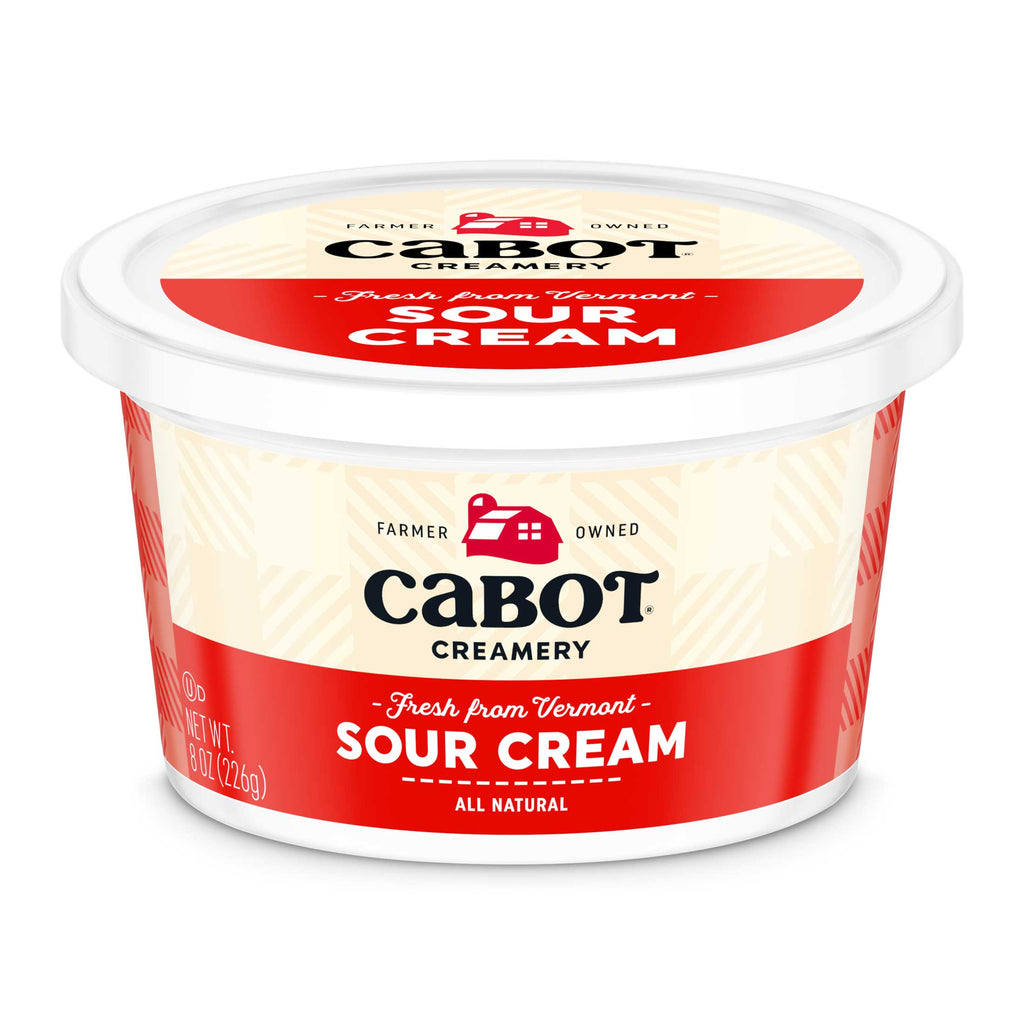 A round 8 oz (226g) container of Cabot Creamery Sour Cream, a creamy cooking staple, displays a red and white label with text stating Farmer Owned, Fresh from Vermont, and All Natural. Ideal for enhancing family dinners.