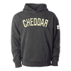 The Northmade Varsity Cheddar Stitched Hoodie is a black pullover featuring "CHEDDAR" in large cream lettering across the chest, a small white patch on the left sleeve, and crafted from soft Vermont fleece for comfort.