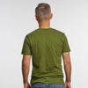 A person with short, light hair faces away from the camera in blue jeans and a green New Duds Life is Cheddar in Vermont T-shirt, made of soft ring-spun cotton, set against a plain white background.