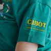 A toddler is wearing the New Duds Cabot x Always With Honor T-shirt, which features yellow “cabot x ALWAYS WITH HONOR” text on the sleeve.