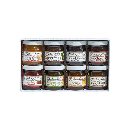 The BHP Cabot Pairing Collection by Provisions International features eight assorted 4 oz. jars of preserves and marmalades in flavors like orange, caramelized fig, spiced plum, tart cherry, raspberry, heirloom apple, apricot orange, and French onion. Each jar with a rustic white label is neatly boxed.