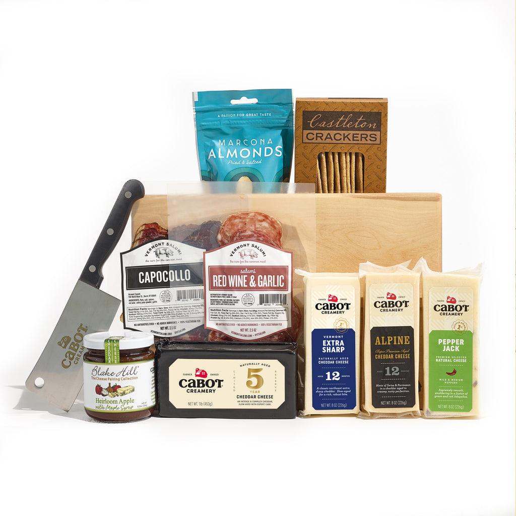 The Ultimate Charcuterie Board Gift Set by Cabot Creamery includes award-winning cheeses, Blake Hill chutney, Castelton crackers, Marcona almonds, capocollo, and red wine & garlic salami. Served on a wooden board with a cheese knife—ideal for any charcuterie spread.