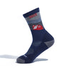 The Darn Tough Vermont Cabot x Darn Tough Socks, Eclipse, are blue and gray Merino wool hiking socks with a red and white barn and silo design—ideal for Vermont Adaptive Veteran Ventures supporters. Displayed on a foot model against a white background.