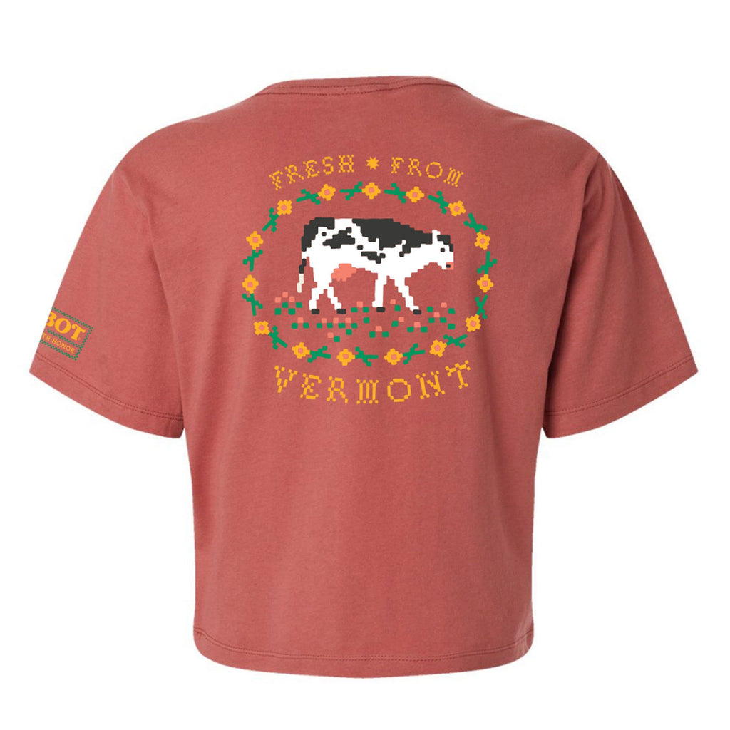 The Cabot x Always With Honor Cropped T-shirt by New Duds is a red, ring-spun cotton top with a boxy fit, showcasing pixel art of a cow in a floral border and yellow “Fresh From Vermont” text on the back.