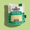 The Cabot x Play Vermont Cheddar Shredder Dog Toy by Play Pet Brands is a plush dog enrichment toy styled like a Cabot Creamery shredded cheddar cheese pack, with green-white checkered design and “Grate Chews” on the front, set on a light green background.