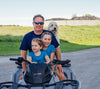 Cabot farmer and grandkids on a 4 wheeler with a dog with farm fields in background.