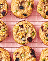 cookies with cheddar nuts chocolate and fruit on a wire rack on a pink countertop