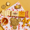Cabot Creamery Habanero Cheddar Cheese—a bold, spicy, lactose free cheese—is served with crackers, cape gooseberries, and honey on a marble board set against a yellow background.