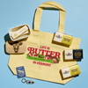 The Cabot Creamery Butter Lover’s Gift Box features a yellow tote bag with “Life is Butter in Vermont” printed on it, surrounded by Cabot butter packages, a cow-adorned butter dish, a Vermont patch, and a checkered keychain—making it the perfect gift or addition for any true butter enthusiast.