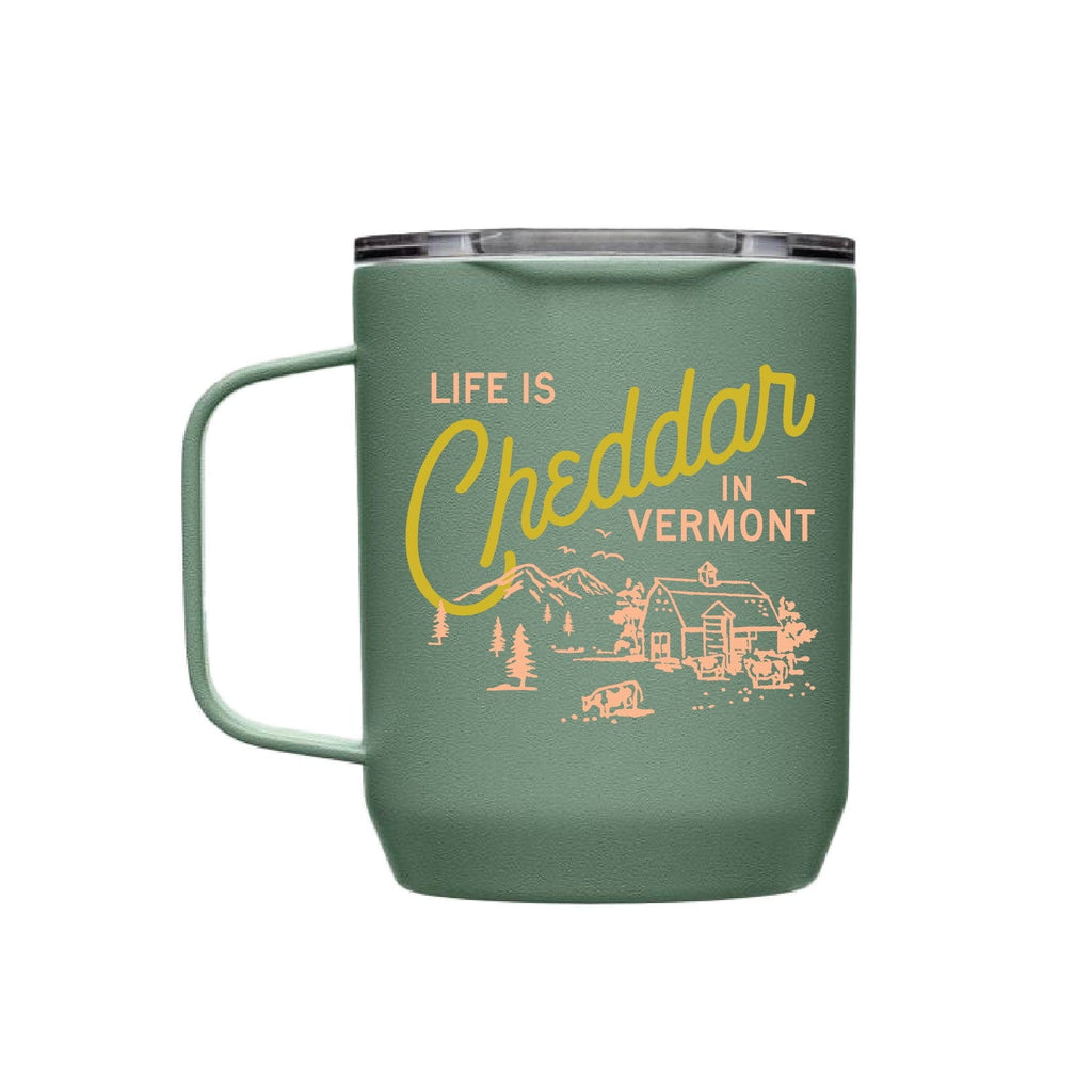 The Pyrographics Life is Cheddar in Vermont Insulated Mug is green with yellow and cream text and showcases mountains, a barn, trees, and a cow.