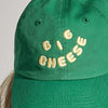 The New Duds Big Cheese Youth Hat is a green cap featuring "BIG CHEESE" embroidered in yellow, puffy letters on the front.
