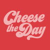 Bold pink text on a red background displays Cheese the Day in playful, cursive font, encapsulating the delicious essence of Cabot Creamery’s Cheese The Day Hoodie.